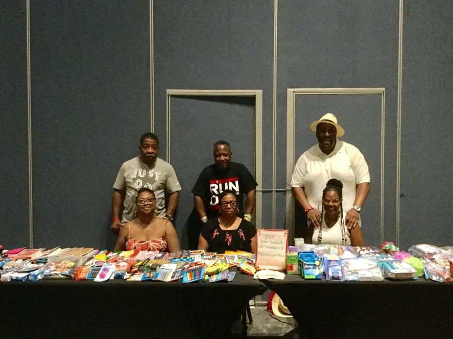 Group behind table of school supplies